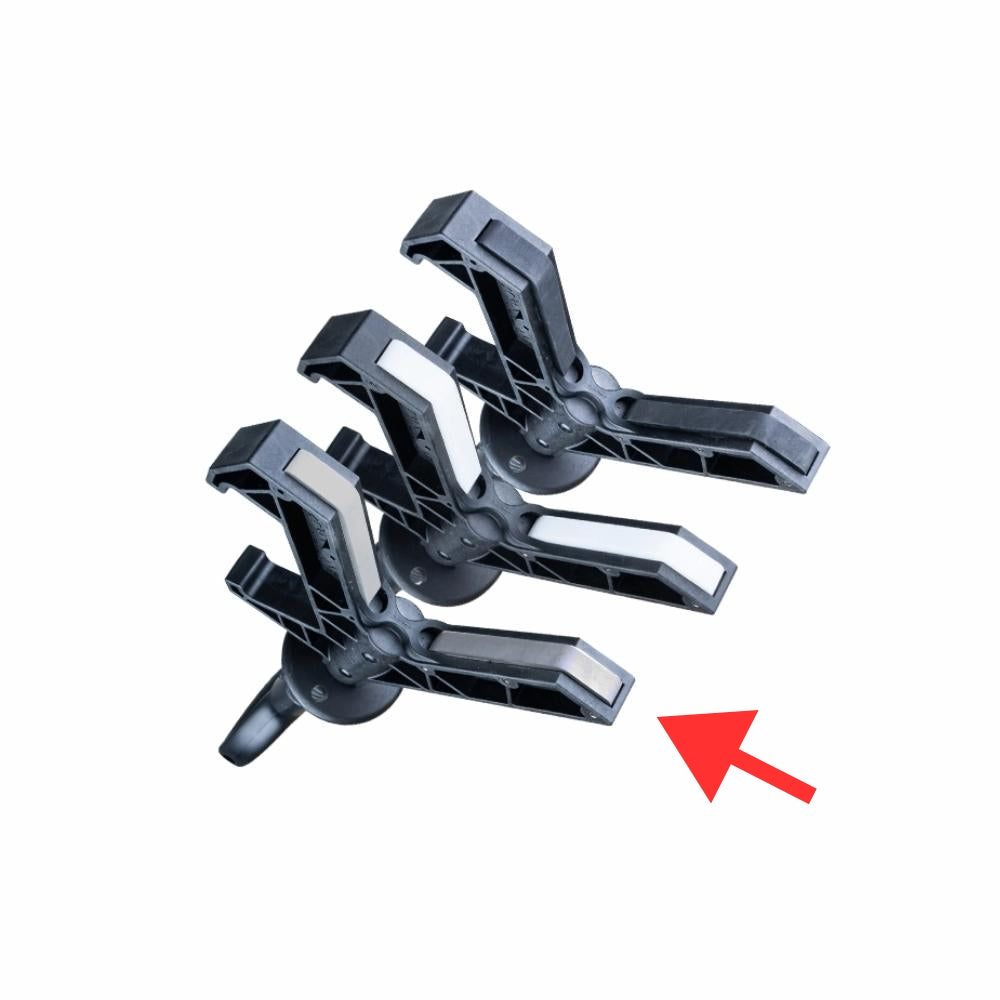 Sort "Y"-formet hoved med tre prong-udvidelser og hvide puder indeni, rød pil peger mod bunden.