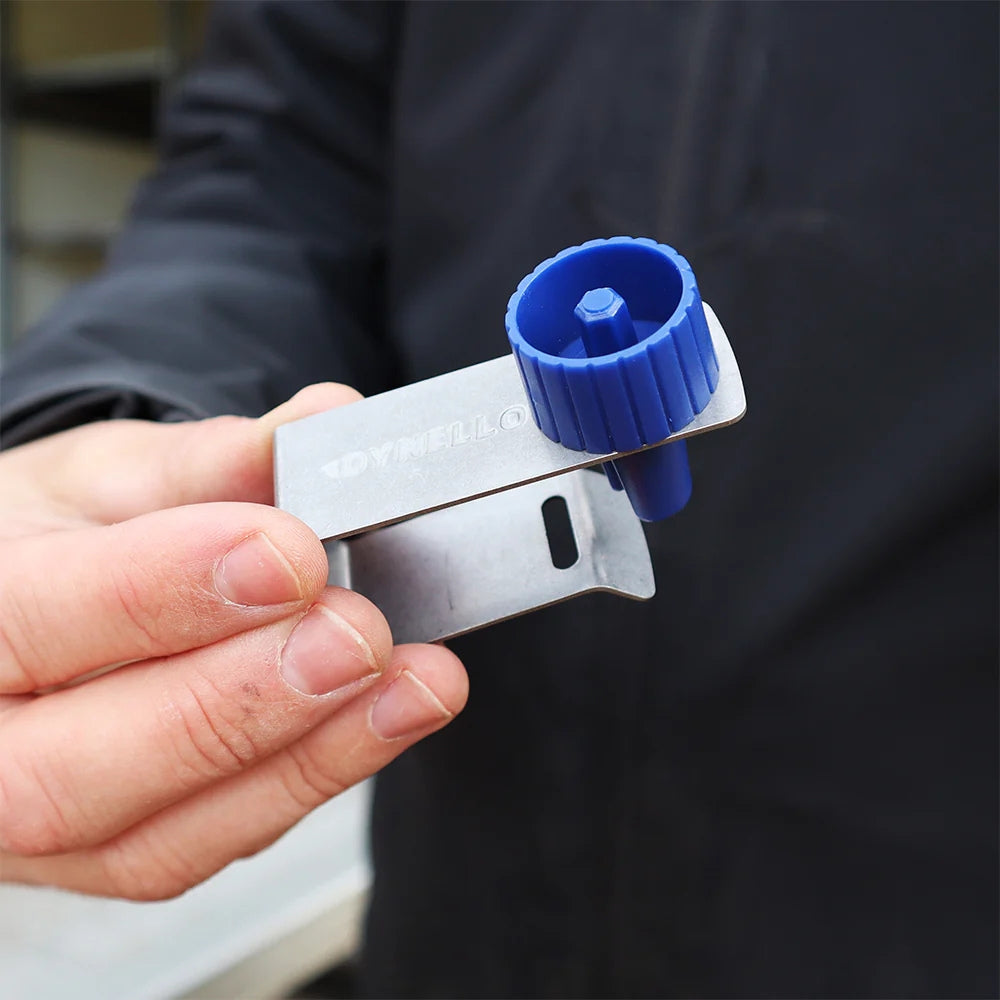 Dynello surringsbånd clip med metalclip og blå winder i hånden på en person.