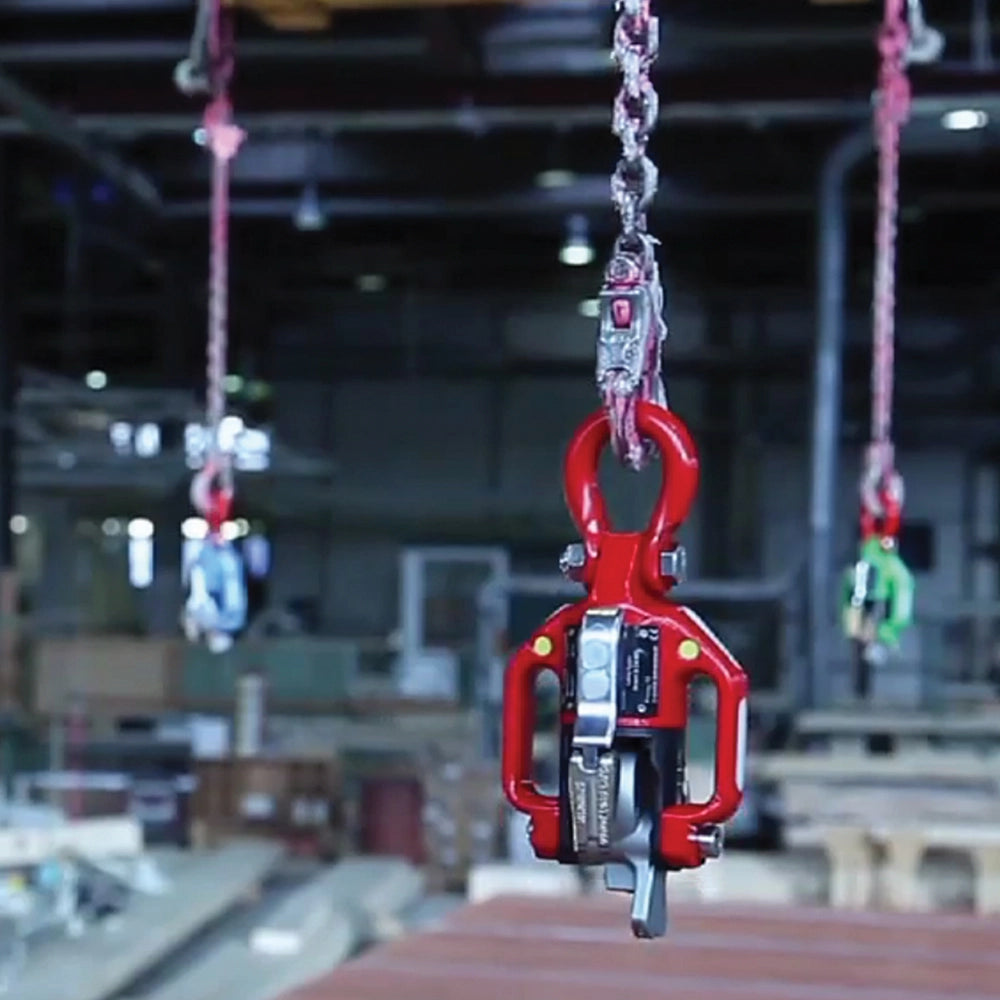 Rød krog hænger fra kæde i industrielt miljø, klar til løfteopgave.