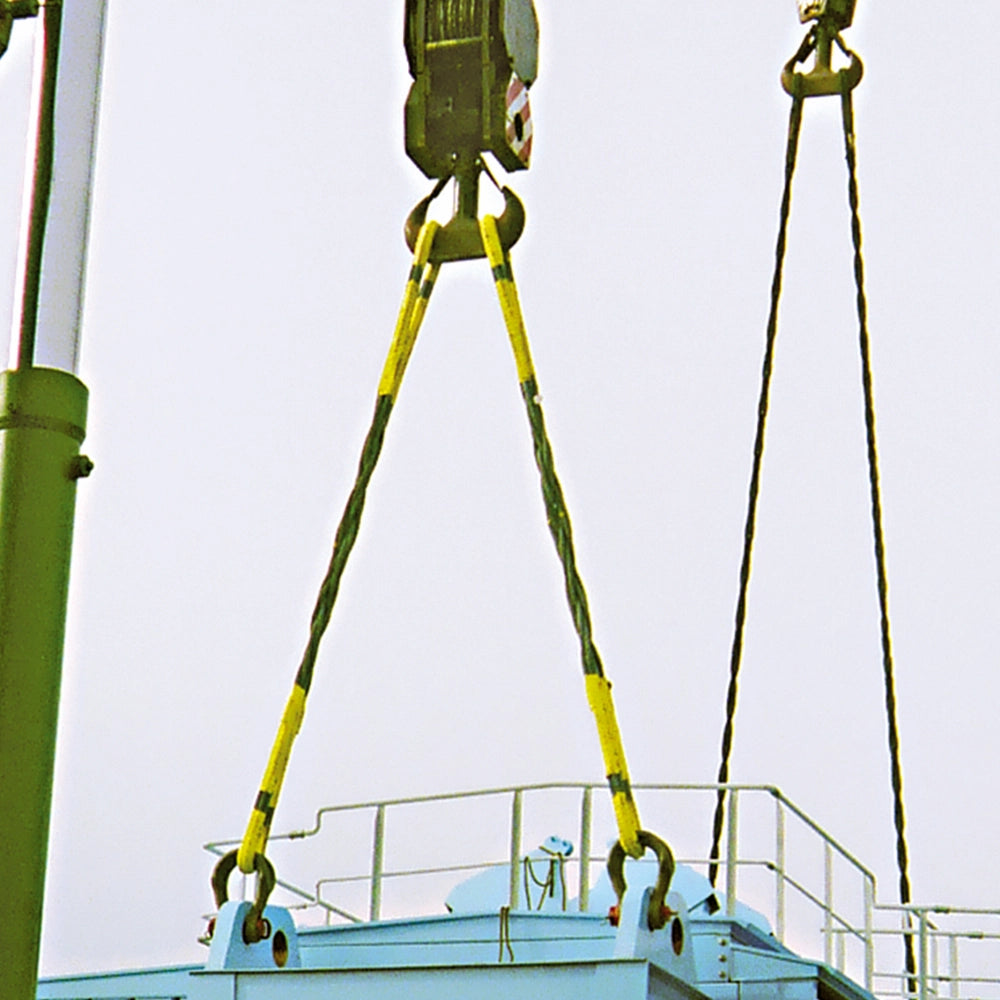 Wirestrop med gule hylstre løfter struktur med kran.