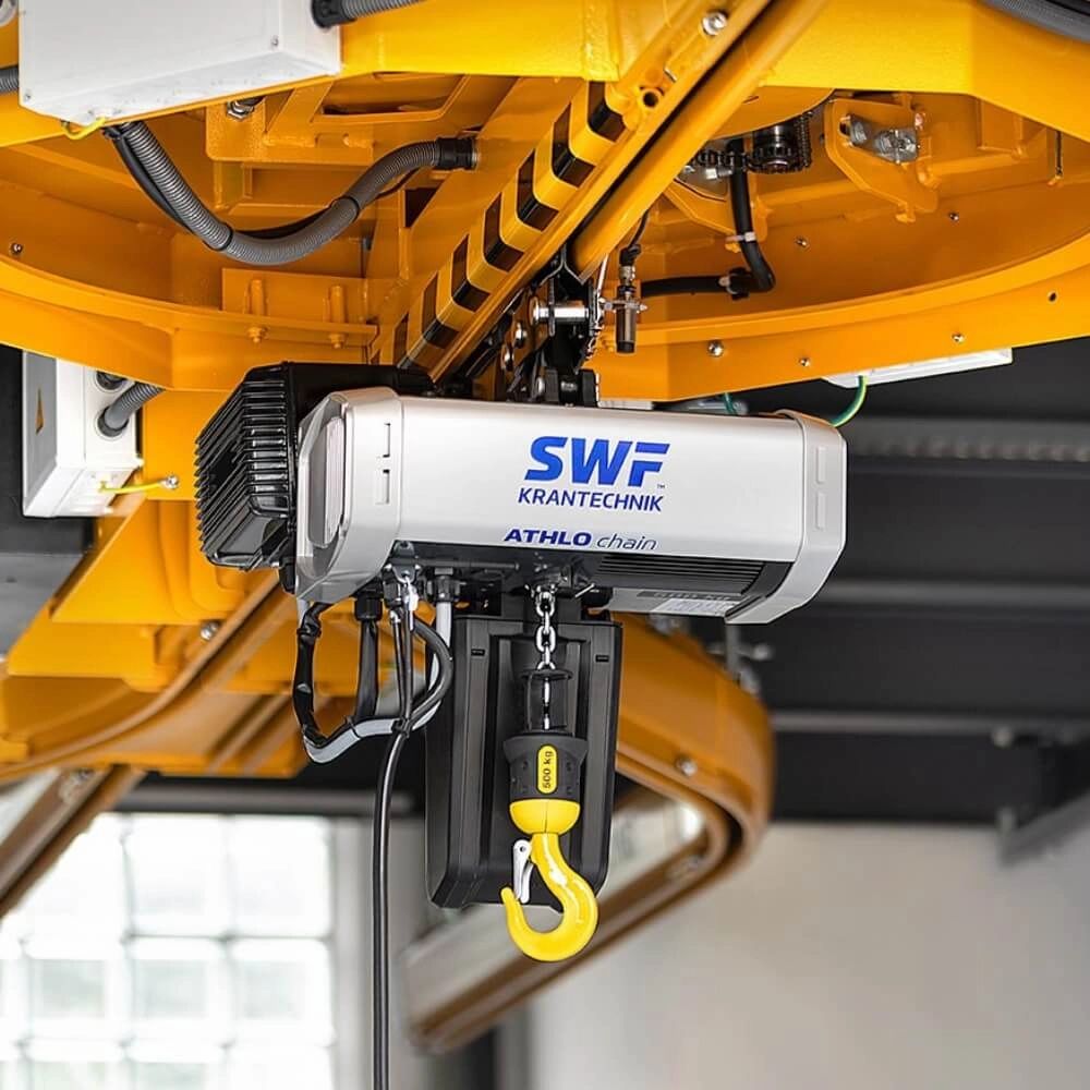 SWF El-talje med gul krog og kæde, monteret på kransystem, mærket "SWF Krantechnik".