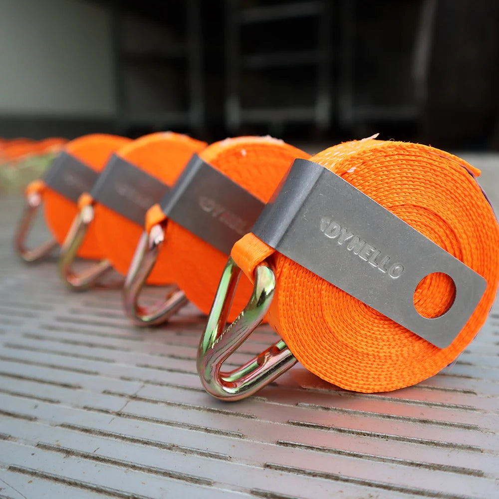 Fire orange surringsbånd med metalclips, "DYNELLO" indgraveret, organiseret på en overflade.
