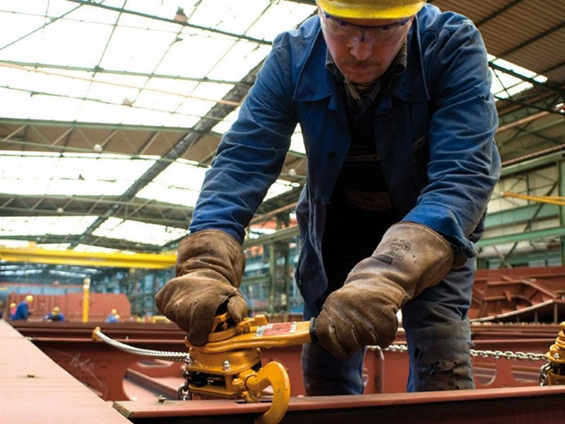 Arbejder i sikkerhedsudstyr håndterer orange KITO Skraldetalje LB5 med kæder i en fabrikshal.