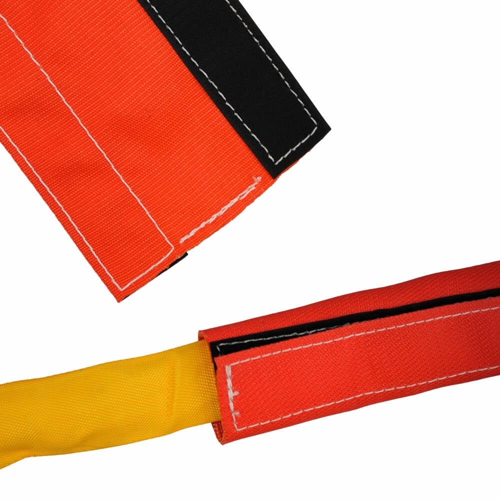 Orange beskyttelseshylster med sorte velcrostrimler, omslutter gul rundsling.