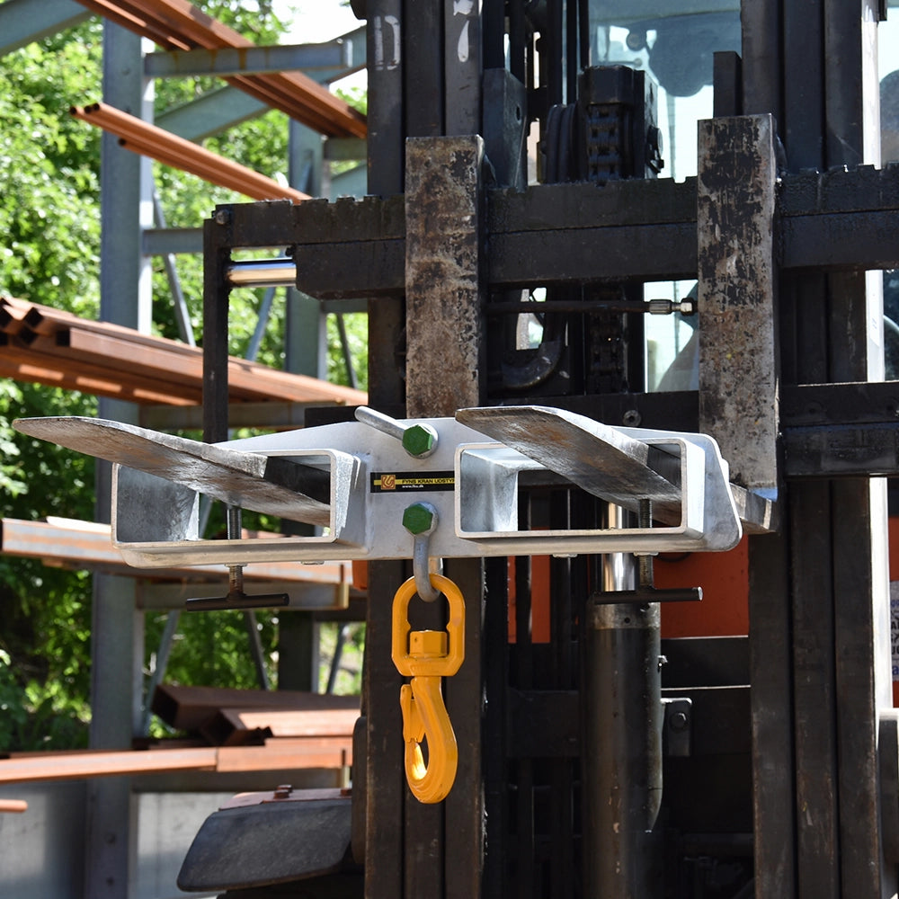 Løfteanordning på gaffeltruck med gul krog, to åbninger, grønne bolte og "WLL 3.000 kg"-mærkat.